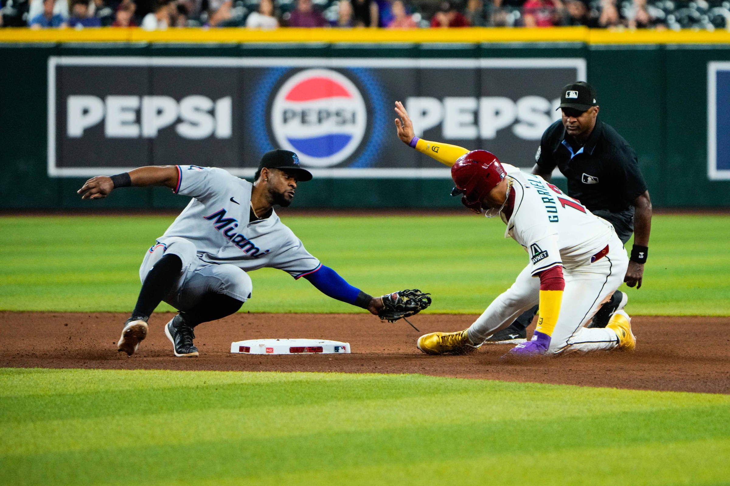 Jun 28, 2025; Phoenix, Arizona, USA; Miami Marlins second base Otto Lopez (6) gets Arizona Diamondbacks outfielder Lourdes Gurriel Jr. (12) out at second base during the seventh inning during a game between the Arizona Diamondbacks and the Miami Marlins at Chase Field. Mandatory Credit: Arianna Grainey-Imagn Images