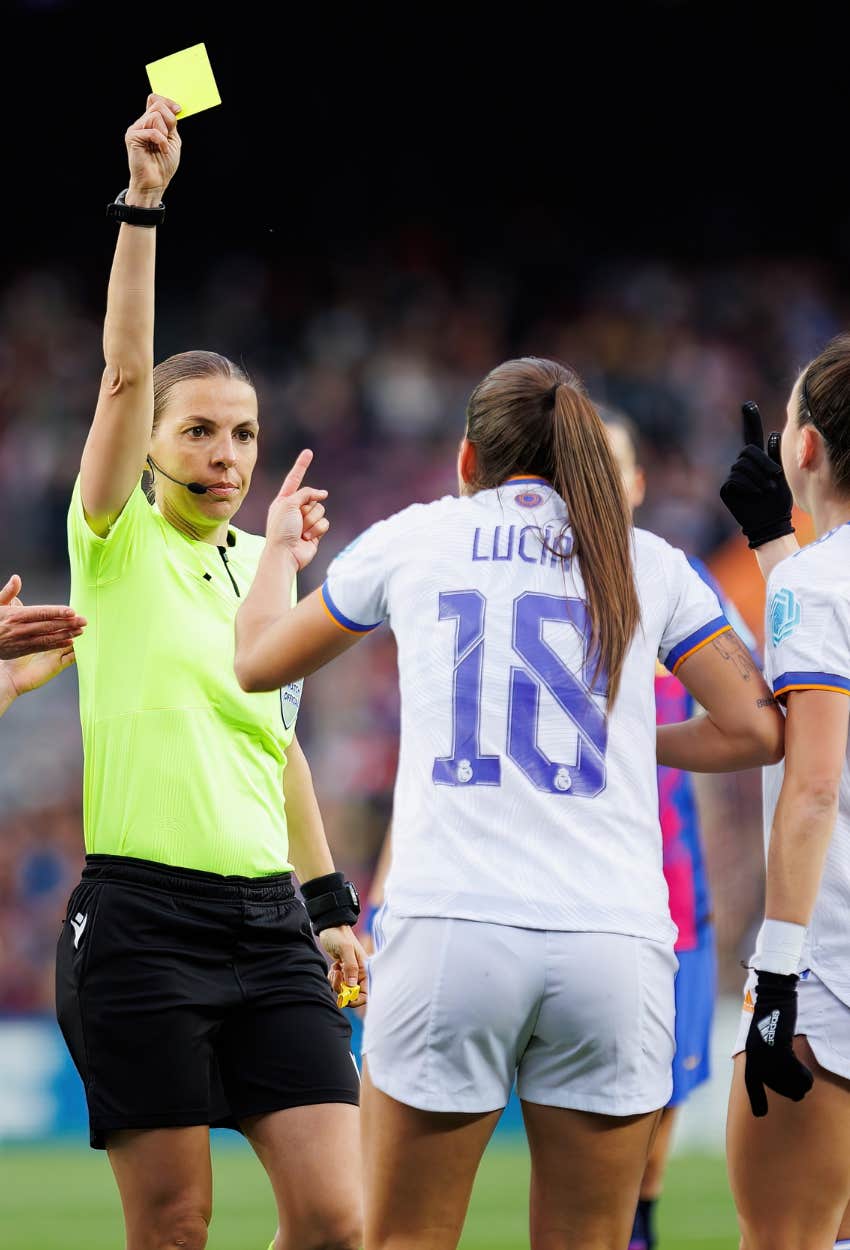A female referee officiating a soccer game