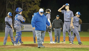 Apopka baseball's former head coach, Bobby Brewer, walks off the mound after speaking with pitcher Tyler Spaid.