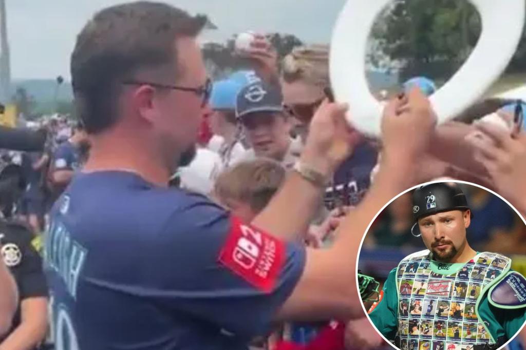 Cal Raleigh signs bathroom item for fan at Little League Classic