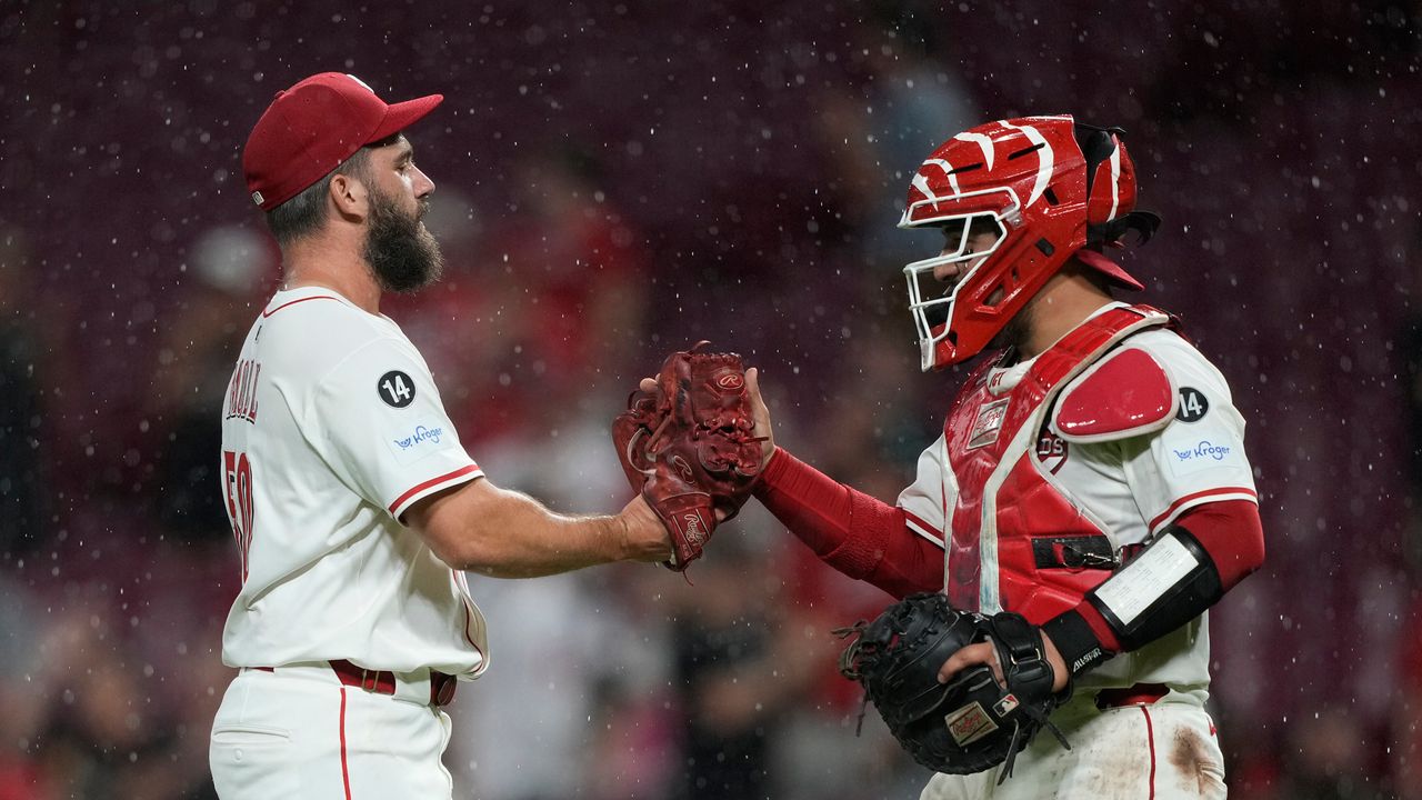Cincinnati Reds pitcher Sam Moll, left, and Cincinnati Reds catcher Jose Trevino celebrate after winning a baseball game against the Philadelphia Phillies Tuesday, Aug. 12, 2025, in Cincinnati. (AP Photo/Carolyn Kaster)