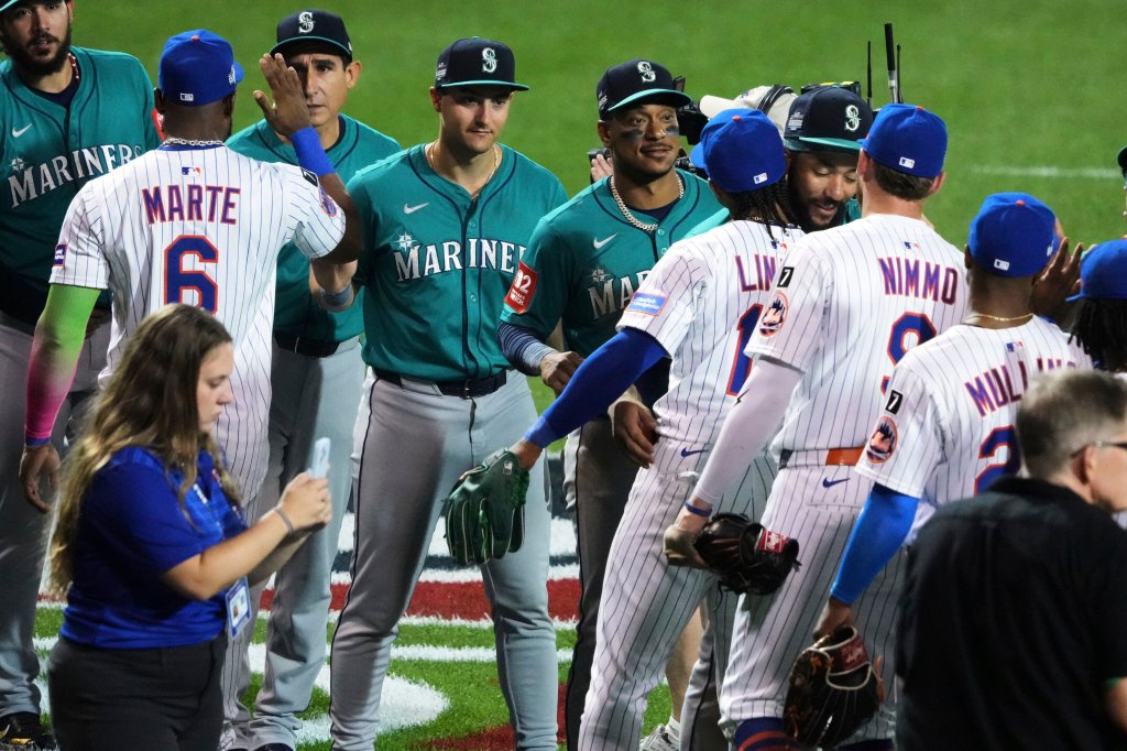 Seattle Mariners and New York Mets baseball players shaking hands.