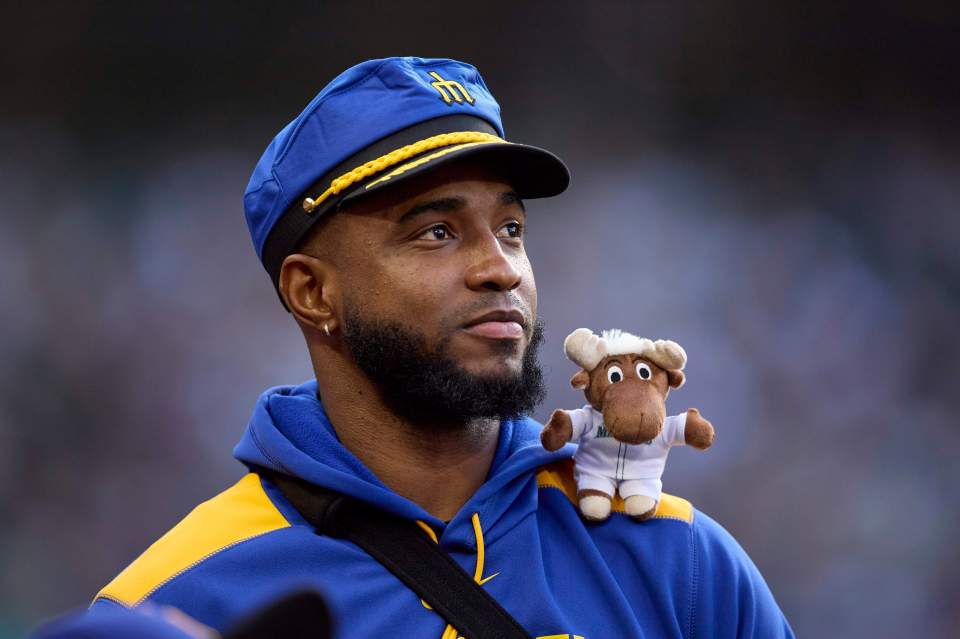 VÃctor Robles of the Seattle Mariners with a team mascot on his shoulder.