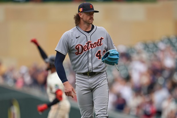 Detroit Tigers starting pitcher Chris Paddack, foreground, stands on the field as Minnesota Twins' Byron Buxton, back left, runs the bases after hitting a solo home run during the third inning of a baseball game Sunday, Aug. 17, 2025, in Minneapolis. (AP Photo/Abbie Parr)