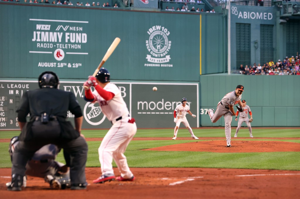 Baltimore Orioles pitcher pitching to a Boston Red Sox batter.
