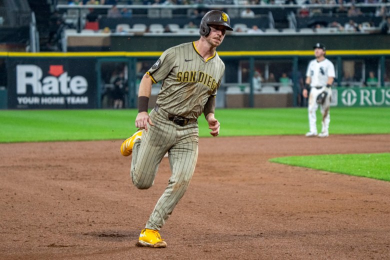 A man in a Padres uniform rounds the bases on baseball diamond.