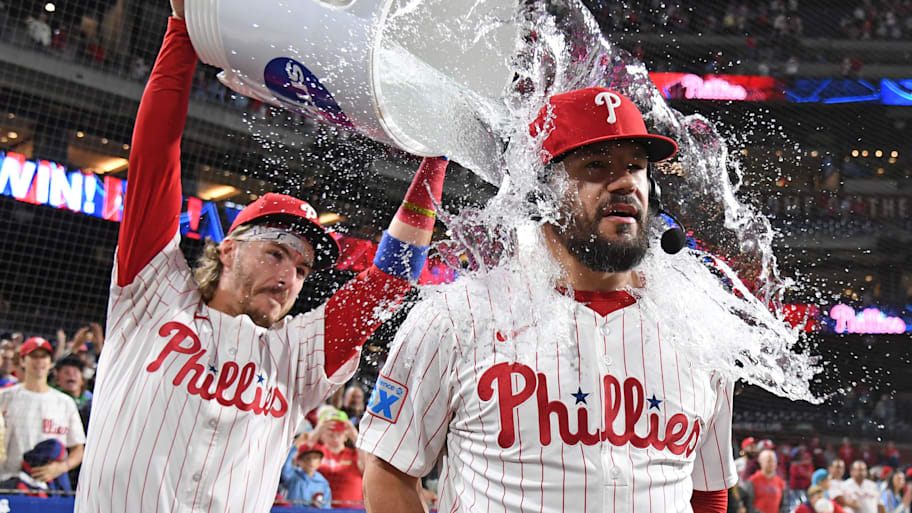 Philadelphia Phillies outfielder Kyle Schwarber (12) has water dumped on him by second base Bryson Stott 