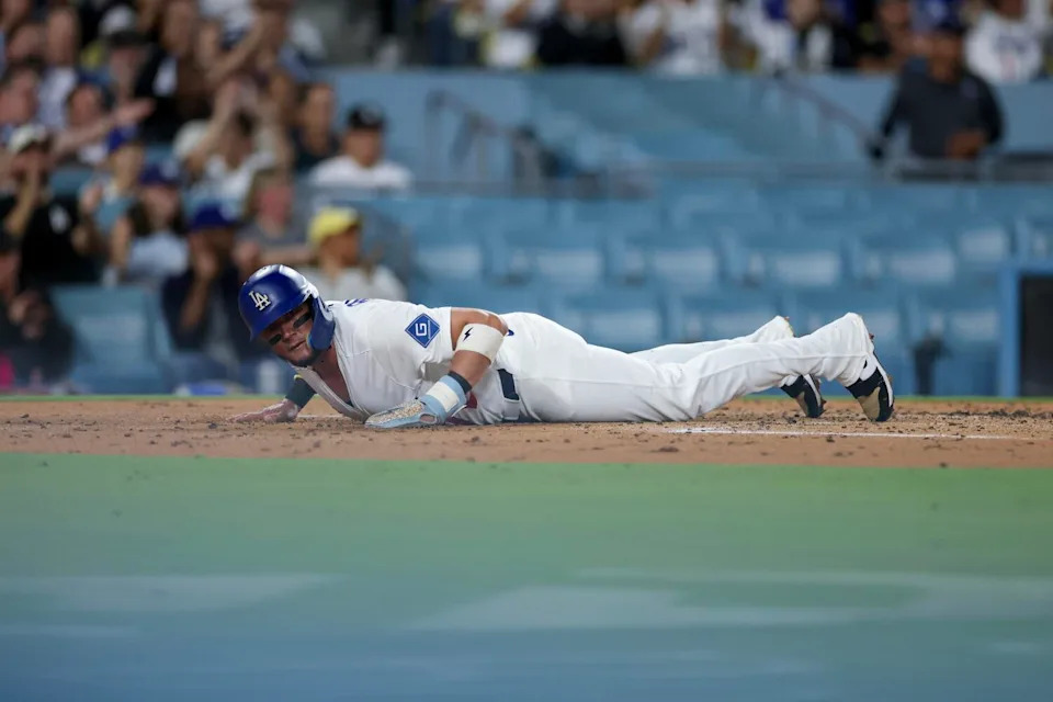Miguel Rojas slides home to score a run in the second inning.