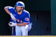 Texas Rangers infielder Josh Smith looks out from the dugout during the first inning of a...