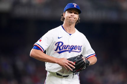 Texas Rangers pitcher Jacob deGrom reacts as he heads to the dugout after pitching the top...
