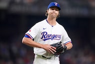 Texas Rangers pitcher Jacob deGrom reacts as he heads to the dugout after pitching the top...