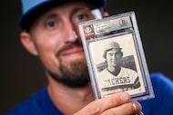 Texas Rangers pitcher Shawn Armstrong shows off a 1976 baseball card for manager Bruce Bochy...