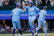 Texas Rangers first base Jake Burger (center) is congratulated by teammate Josh Jung (6)...
