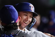 Texas Rangers' Wyatt Langford, right, celebrates in the dugout after hitting a solo home run...