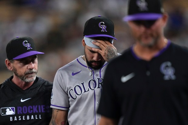 Colorado Rockies first baseman Warming Bernabel is walked off the...