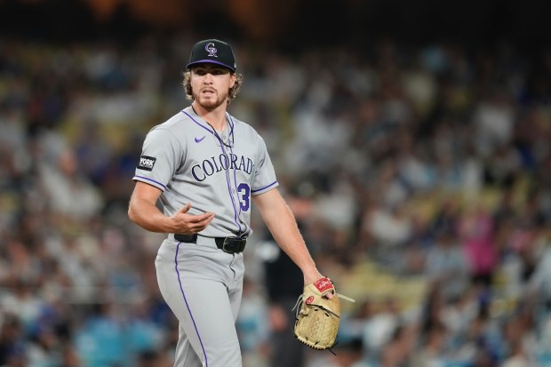 Colorado Rockies starting pitcher Chase Dollander gestures after giving up...