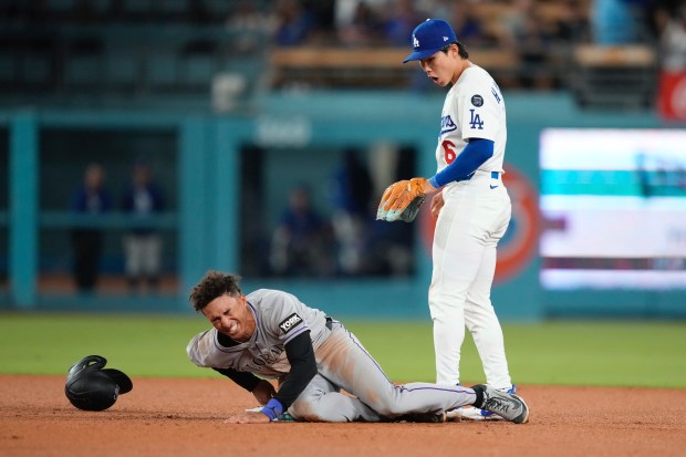 The Colorado Rockies’ Ryan Ritter, left, winces after injuring himself...