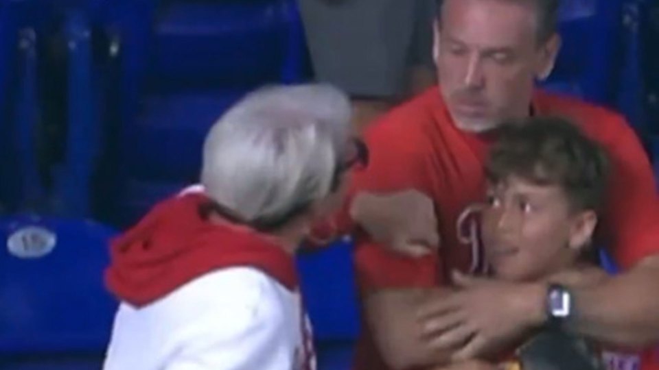 A woman arguing with a man and boy about a baseball.