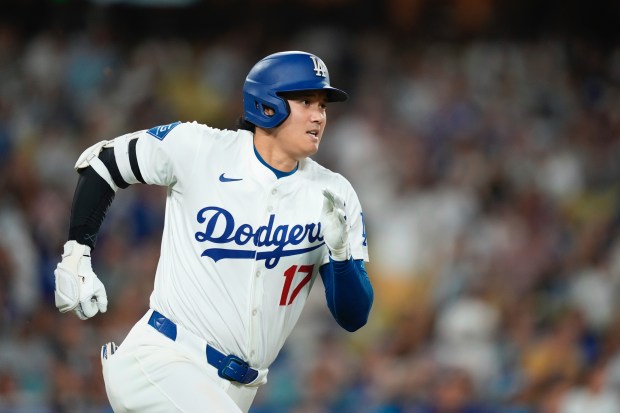 Dodgers star Shohei Ohtani sprints up the first base line...