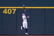 Texas Rangers outfielder Michael Helman (24) catches a fly hit by Milwaukee Brewers...