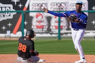 Texas Rangers shortstop Sebastian Walcott tries to turn a double play after forcing out...