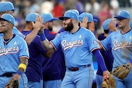 Texas Rangers first base Jake Burger (center) receives a high five from manager Bruce Bochy...