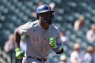 Texas Rangers' Adolis García runs to first base after hitting an RBI single during the...
