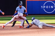 New York Mets shortstop Francisco Lindor, front left, applies a late tag to Texas Ranger's...