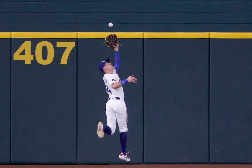 Texas Rangers outfielder Michael Helman (24) catches a fly ball hit by Milwaukee Brewers...