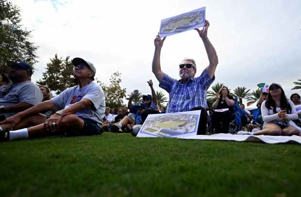 Dodger fan Robert Gonzalez, from Culver City, holds up an...