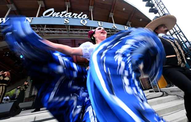 A ballet folklorico group performs for Dodger fans as they...