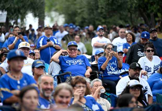 Dodger fans look on during the official announcement of the...