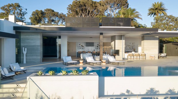 Infinity pool with white reclining chairs.