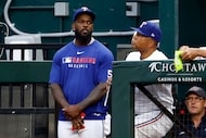 Texas Rangers outfielder Adolis Garcia talks with third base coach Tony Beasley during the...