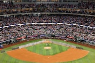 The Texas Rangers and the Boston Red Sox stand on the field as country music singer Randall...