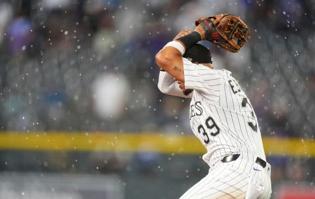 Colorado Rockies second baseman Thairo Estrada reacts after losing a pop single in the rain off the bat of Los Angeles Dodgers' Max Muncy in the sixth inning of a baseball game Wednesday, June 25, 2025, in Denver. (AP Photo/David Zalubowski)