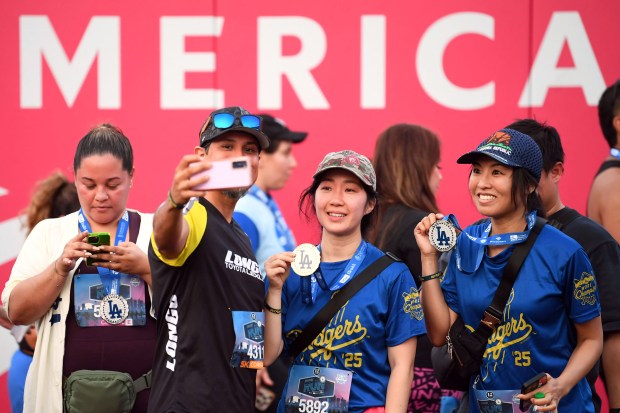 Competitors pose for a selfie as they walk the warning...