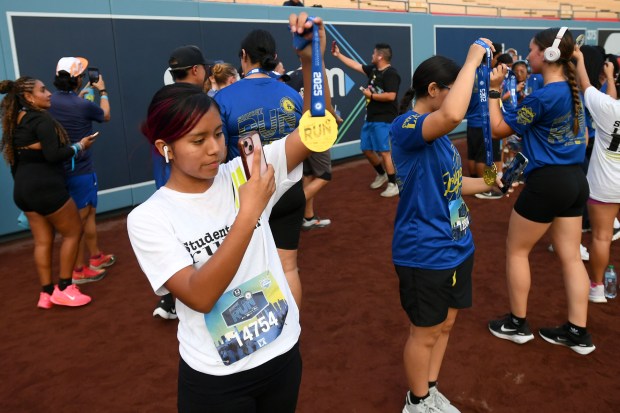 Racers document their achievement following the 5K race during the...