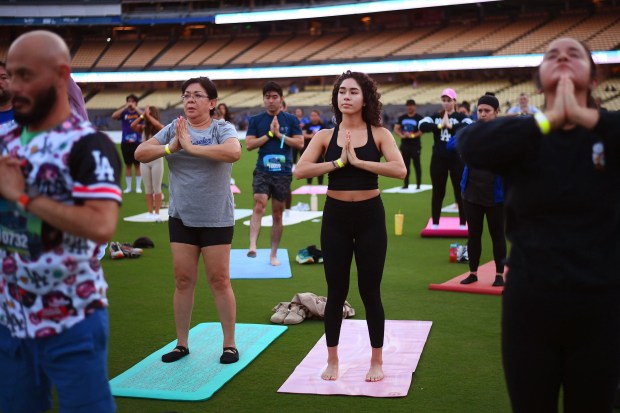 Yoga enthusiasts take to the outfield at Dodger Stadium as...
