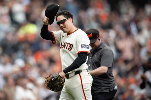 San Francisco Giants first baseman Wilmer Flores, left, walks off the field after being replaced by first baseman Bryce Eldridge (not shown) during the third inning of a baseball game against the Colorado Rockies, Sunday, Sept. 28, 2025, in San Francisco. (AP Photo/Thien-An Truong)