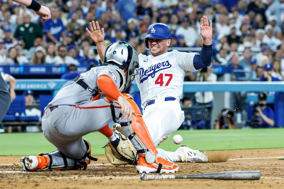 Dodgers baserunner Ben Rortvedt slides safely into home plate after Giants catcher Patrick Bailey loses the ball.