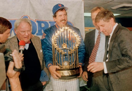 FILE - New York Mets Manager Davey Johnson, center, holds baseball's World Series trophy on...