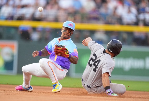 New York Yankees' Jasson Domínguez, right, steals second as Colorado Rockies second baseman Adael Amador struggles to field the throw in the fourth inning of a baseball game Friday, May 23, 2025, in Denver. (AP Photo/David Zalubowski)