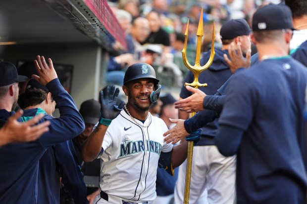 Seattle Mariners' Julio Rodriguez holds the trident while celebrating his three-run home run against the Chicago White Sox during the second inning of a baseball game Wednesday, Aug. 6, 2025, in Seattle. (AP Photo/Lindsey Wasson)