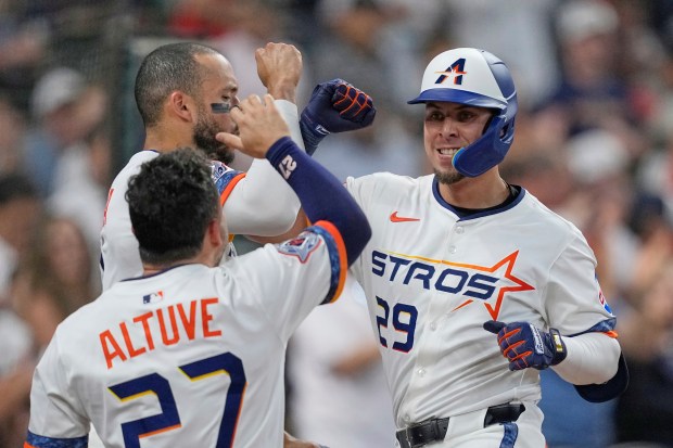 The Houston Astros’ Ramón Urías, right, celebrates with teammates Jose...
