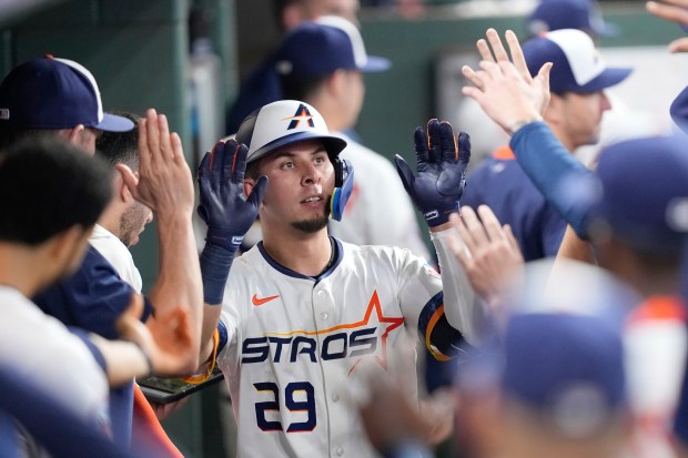 The Houston Astros’ Ramón Urías celebrates in the dugout after...