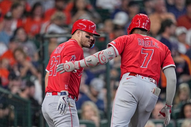 The Angels’ Jo Adell, right, celebrates with teammate Mike Trout...