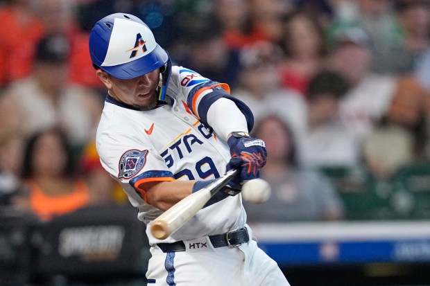 The Houston Astros’ Ramón Urías hits an RBI single during...
