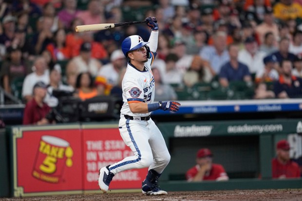 The Houston Astros’ Ramón Urías hits an RBI single during...