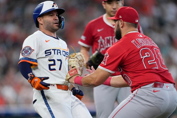 The Houston Astros’ Jose Altuve, left, is tagged out by...